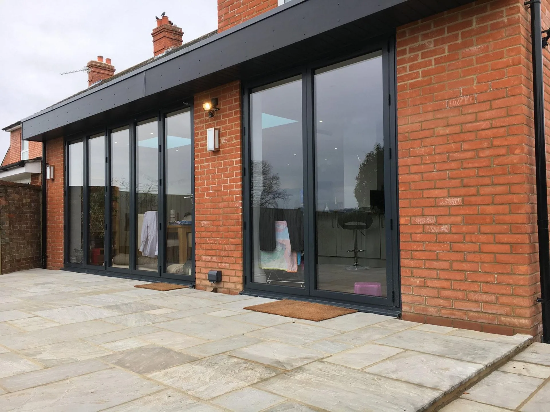 Brick single-storey extension with bi-fold doors onto a stone patio