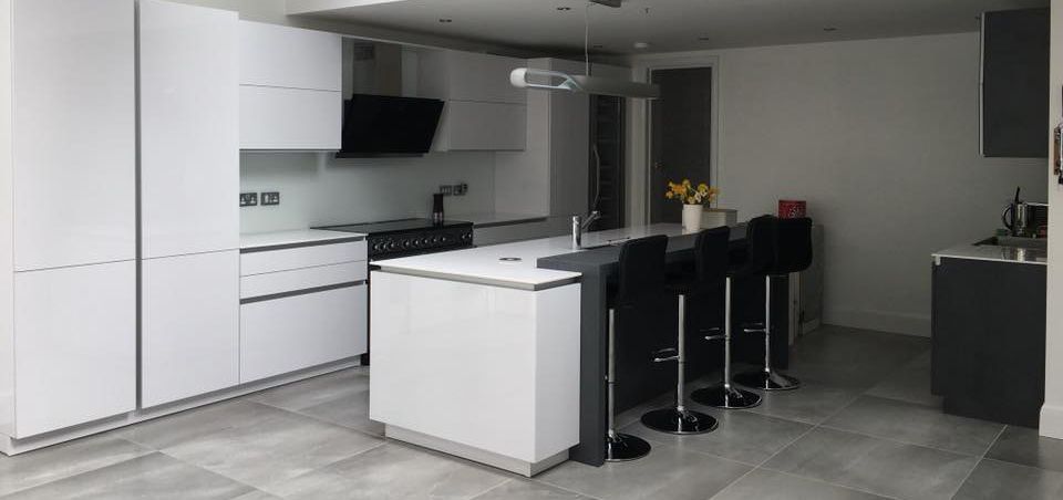 White gloss kitchen with an island and bar stools