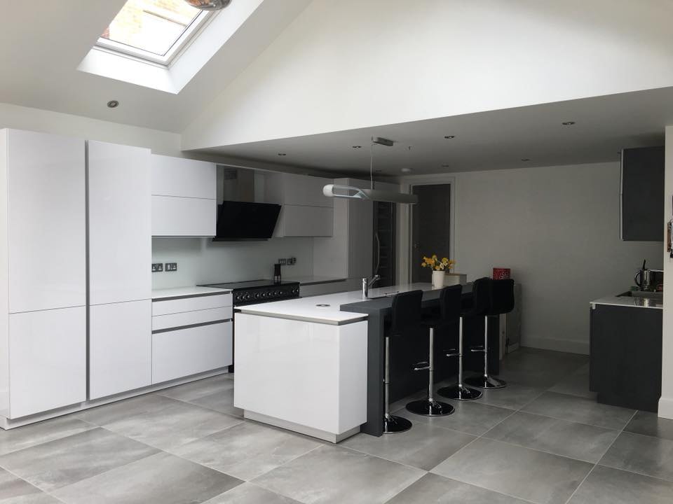 White kitchen with an island under a roof light