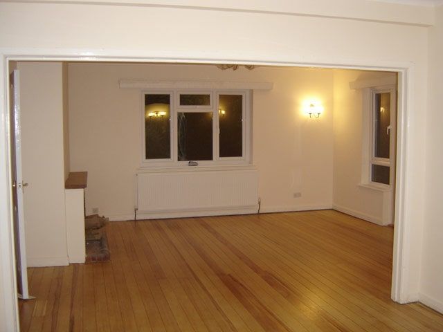 Refurbished room with an oak floor and wall lights