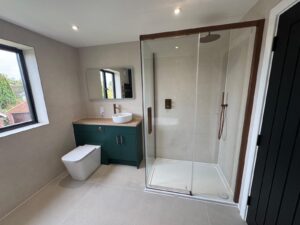 Professional bathroom fitters installing waterproof tanking and premium floor tiles in a Winchester, Hampshire home.