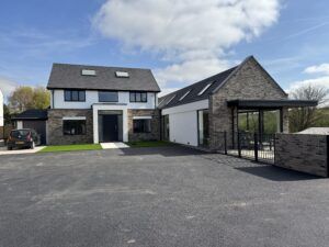 Completed modern house renovation in Southampton by Caws Carpentry featuring white render, grey brick, anthracite windows and contemporary porch entrance.